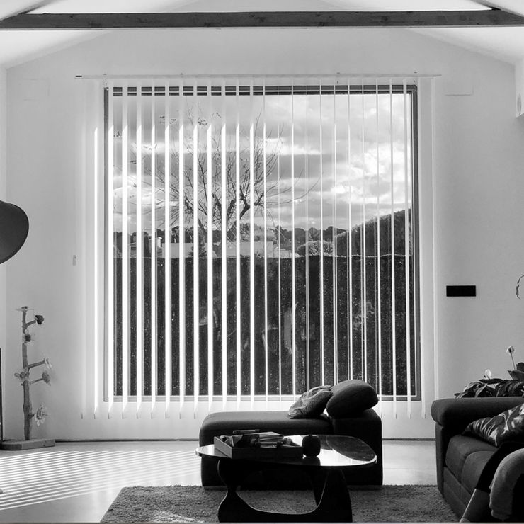 imagen en blanco y negro de salón, se ve un sofá, un sillón, una mesa de te y la ventana al exterior